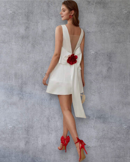 Vestido corto blanco con lazo y flor en la espalda